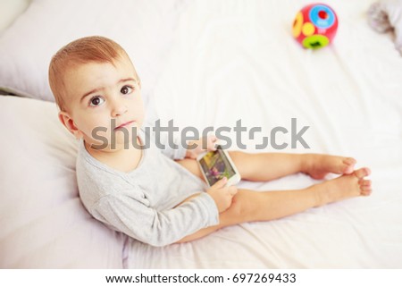 Lonely kid with mobile phone in his hands