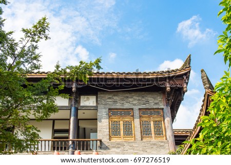 A corner of the folk architecture set against the green leaves of the blue sky and white clouds