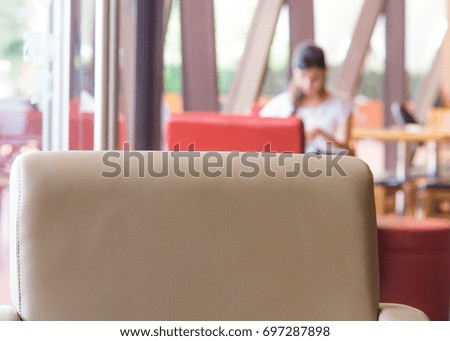 Blurred woman using phone in cafe.