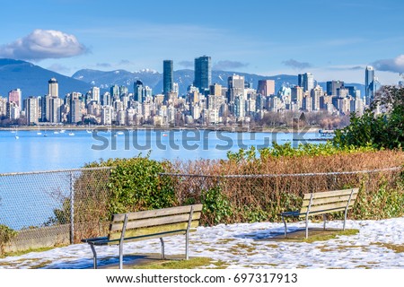 View on beautiful Vancouver park and harbour over snow mountains.