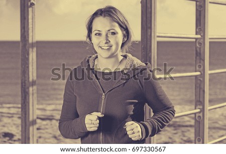 Young beautiful  positive woman jogging at sea beach
