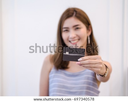 Asian Woman with smiley face showing her credit card . credit card using behavior concept