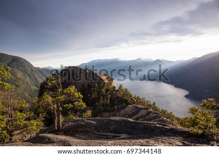 Beautiful mountain landscape view from the top of The Chief Peak with Howe Sound in the background. Picture taken in Squamish, North of Vancouver, British Columbia, Canada, during a cloudy sunset.