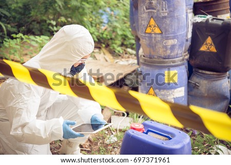 Asian scientist wear Chemical protection suit check danger chemical,working at dangerous zone Royalty-Free Stock Photo #697371961