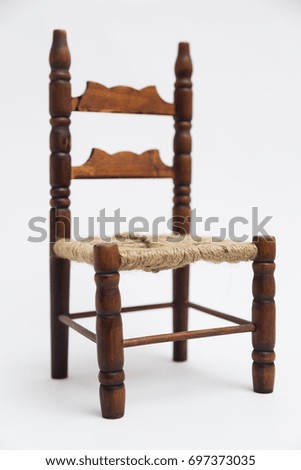 Old vintage wooden retro classic small brown handmade coiled carved elegant chair with decorative elements on white background.