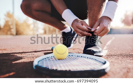 Tennis player tying sport shoes. Sport, recreation concept Royalty-Free Stock Photo #697394095