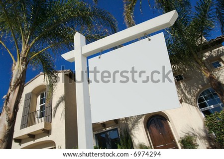 Blank Real Estate Sign and House with dramatic sky background. Ready for your own message.