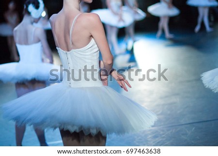 acting skills, dramatic character, theater concept. slim back of young female ballet dancer, dressed in snowy white dress with tutu, playing with her colleagues on the stage