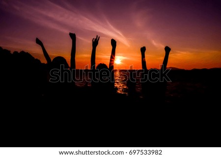 Silhouette landscape and people sunbathe on the beach with colorful sunset background. People are happiness and relax in holiday.
