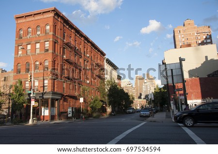 A street runs between mid rise buildings in Manhattan one bright afternoon