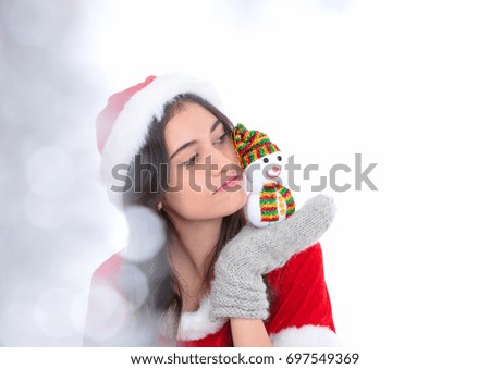 Young girl celebrating xmas playing with snowman on hand. Tree on a background. Holidays, winter and celebration concept.