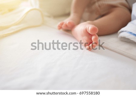 Newborn baby's foot on white blanket closeup