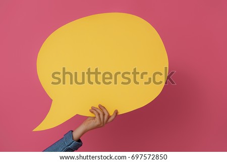Hand with cartoon speech on colorful background. Yellow, pink and blue colors.