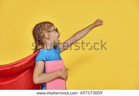 Little child plays superhero. Kid on the background of bright color wall. Education and success concept. Yellow, red and  blue.