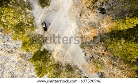 aerial view of snowy forest in sunny winter day with country road. drone photography - panoramic image