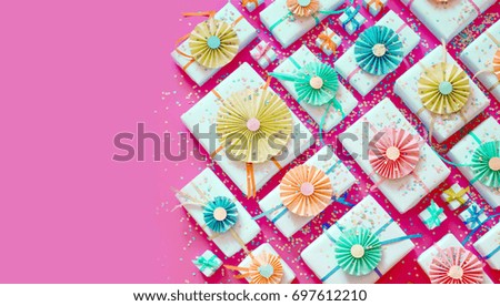 Bright pink background. Many gifts of different sizes.a