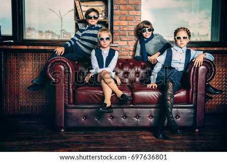 Group of modern children posing in school uniform and sunglasses in luxurious apartments. School fashion.  Royalty-Free Stock Photo #697636801