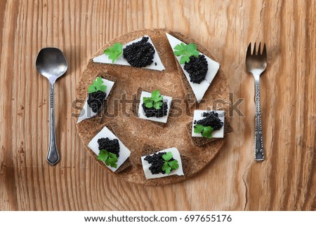 snack black caviar on a wooden brown background