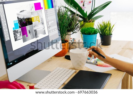 Graphic designer using pen tablet to design. All screen graphics are made up.