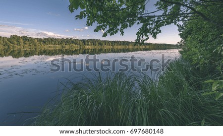 reflection of clouds in the lake with forest  and trees in background and horizon line - vintage film effect