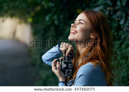 Beautiful woman with a retro camera smiling and looking up, fashion, beauty                               