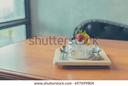 vintage tone image of mixed fruit Cake with blue berry strawberry and orange on wood table.