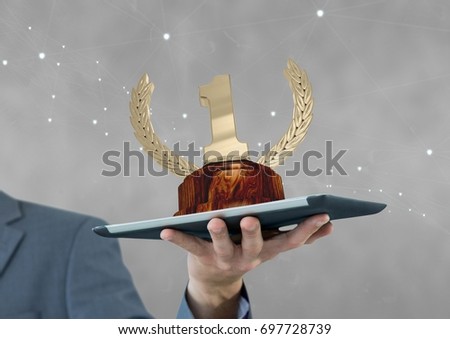 Digital composite of Person holding a tablet with a trophy