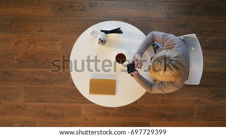 Young business women holding mobile phone text message during rest in coffee shop