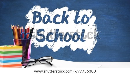 Digital composite of Desk foreground with blackboard graphics of Back to school