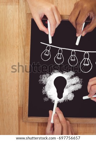 Digital composite of Hands drawing light bulbs on blackboard