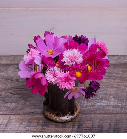 A bouquet of pink and purple flowers cosmea or cosmos with ribbon on rustic wooden boards. Copy space. Mother's, Valentines, Women's, Wedding Day concept.