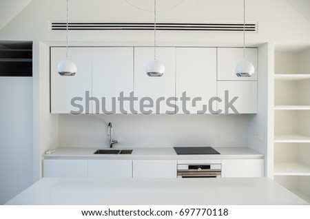 Generic minimalist clean interior design empty kitchen with lighting and appliances mounted. Concept image Royalty-Free Stock Photo #697770118