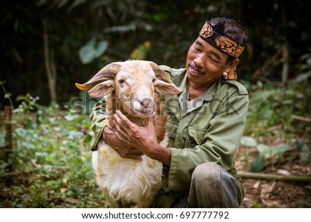 Indonesian Villager With HIs Goat Royalty-Free Stock Photo #697777792