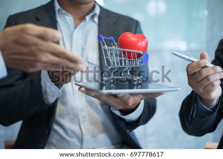 businessman put shopping cart on tablet for sale, shopping concept