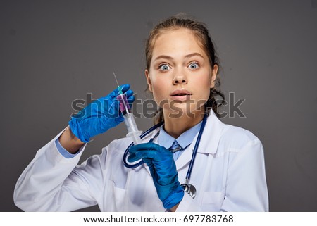 Young doctor on gray background portrait                               