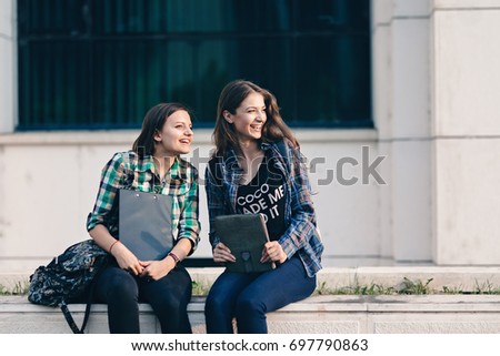 It is a nice view to see the sun at evening.Beautiful girl engaged in conversation with her friend after the class forgets everything, dissolves into the beautiful sight of evening sun.Back to school