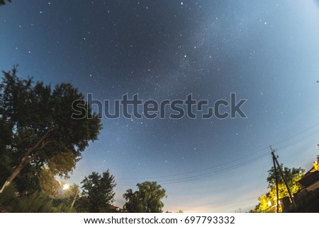 Starry sky in the summer evening over the village