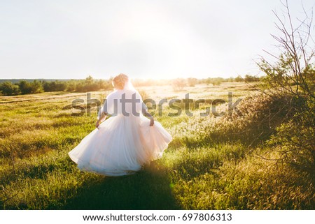 The beautiful blonde bride on a walk on nature outdoors