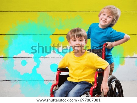 Digital composite of Disabled boy in wheelchair with painted yellow background and settings cogs gears