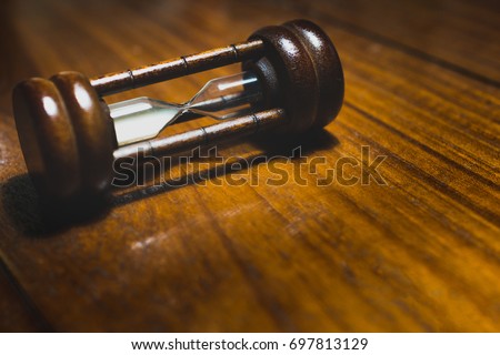 Hourglass, sand glass lay down on wooden table.