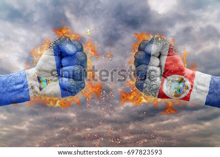 Two fist with the flag of Nicaragua and Costa Rica faced at each other ready for fight