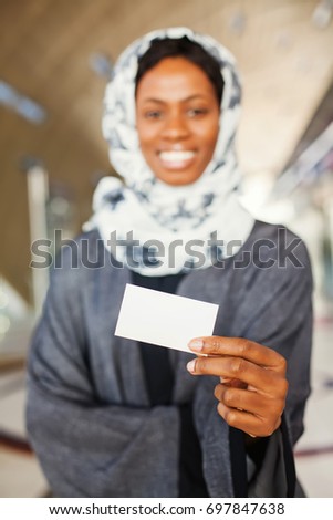 beautiful young african woman holding a blank name card 