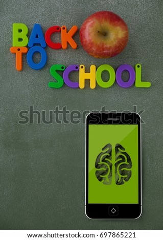 Digital composite of Phone on a school table with brain icon on screen