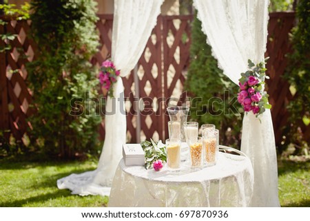 Details of wedding ceremony and tradition of making family amulet from different grain, outdoor. Peony decorations in the wedding celebration