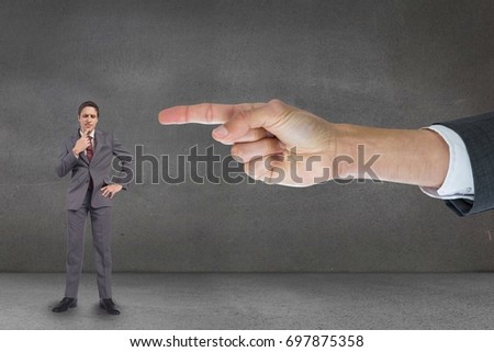 Digital composite of Hand pointing at business man against grey background