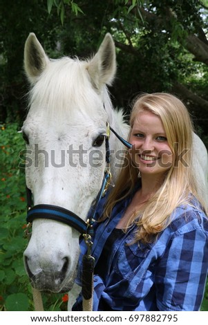 A beautiful young blonde woman and her white steed