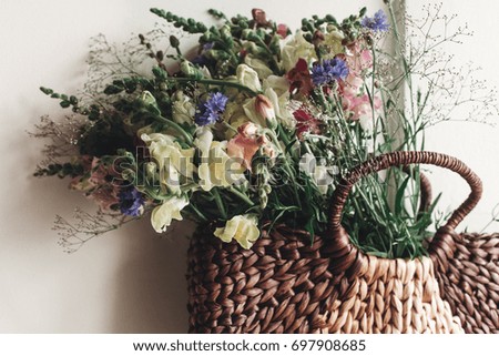 beautiful  wildflowers in wicker bag at rustic window. colorful flowers in brown basket in sunlight, space for text. rural atmospheric moment. rustic wedding, creative summer picture