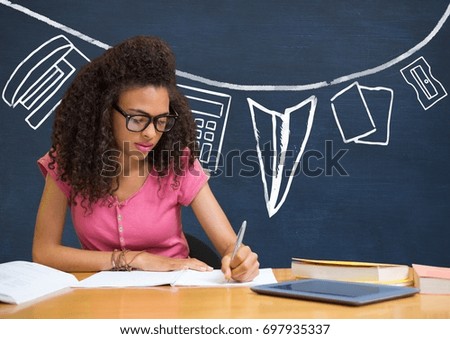 Digital composite of Student girl at table writing against blue blackboard with school and education graphic