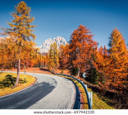 Fantastic sunny view of Dolomite Alps with yellow larch trees. Colorful autumn scene of mountains. Giau pass location, Italy, Europe. Artistic style post processed photo.