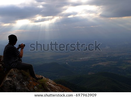 photographer on the top mountain in dark cloud